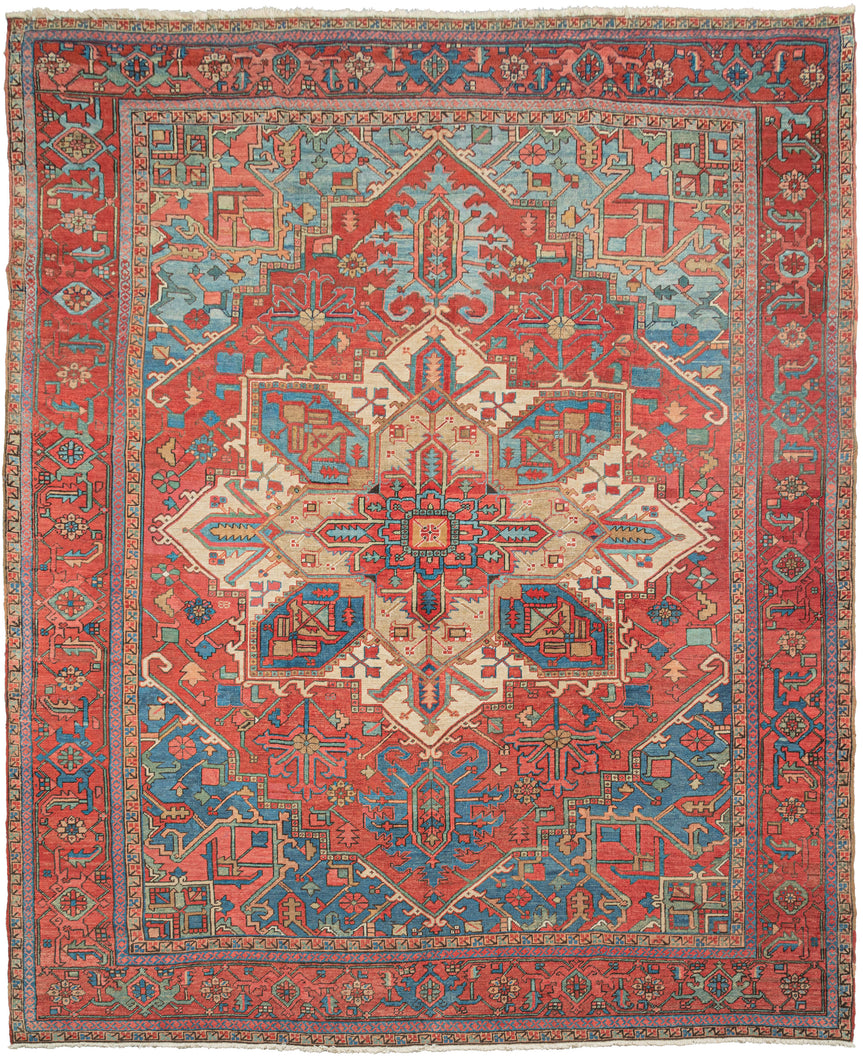 19th century Heriz Serapi large rug featuring the classic Heriz layout with a graphic geometric central medallion. The rich lacquer red in the field and the border contrast perfectly with the brilliant blue which shifts from cobalt to an icy blue like tropical waters shifting in depth. The central medallion showcases both blue as well both ivory and soft camel adding depth and nuance to the traditionally heavier focal point to mesmerizing effect.