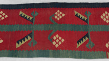 This Sarkoy kilim was in the Balkans during the 19th century.  It features a border fragment with a grape vine motif. An inner and outer border band is shown in light and dark blue. The vine is rendered in light blue with ivory grape bunches and two tone leaves of pistachio and navy on a rich red ground. Very old for type with great color and subject, would look lovely hung on a wall.