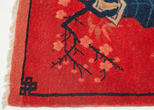 This Ningxia rug was handwoven in China during the first quarter of the 20th century.

The main design is composed of various porcelain vases filled with fruit and plants such as cherry blossoms on wooden stands.This red tone is very auspicious and often associated with prosperity. It is framed by a thin blue border that forms an endless knot symbol at each corner.