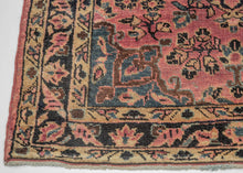 This Sarouk rug was handwoven during the second quarter of the 20th century.&nbsp;

It features of an deep navy central medallion on a crimson ground. The field is filled with fine floral sprays and balanced by four scalloped cornices woven in light blue. The border is composed of a straightforward floral meander in the same deep navy almost black ground of the central medallion