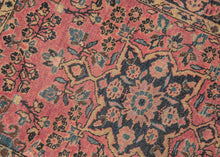 This Sarouk rug was handwoven during the second quarter of the 20th century.&nbsp;

It features of an deep navy central medallion on a crimson ground. The field is filled with fine floral sprays and balanced by four scalloped cornices woven in light blue. The border is composed of a straightforward floral meander in the same deep navy almost black ground of the central medallion