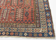 This Shirvan was handwoven during the early 20th century in the Eastern Caucasus.

It features an allover design in diagonal rows on an earthy red ground.&nbsp;The field is composed of tree-like forms each surrounded by rosettes. In between each tree-like form are a geometric flower and a form with opposing bird-like figures.