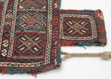 Luri namkadan saltbag soumak woven face with a pattern of bur-like protection symbols in two rows and on the neck of the bag. The top row breaks off to the left mid symbol while the bottom breaks off to the right mid bur giving the composition the illusion of movement. The pattern is simple yet complex with rich and saturated blues, reds, green, and apricot with chocolate brown and a bright white that really pops. The white is achieved by using cotton and can be seen on back of the bag 