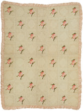 It features abstracted roses that alternate with open squares and is framed by a ruffled silk border. The roses in rendered in light and dark pink petals with light and dark green leaves and each feature a yellow silk center. The small blanket has a soft and dainty feel and was likely intended for a newborn baby. 19th century americana