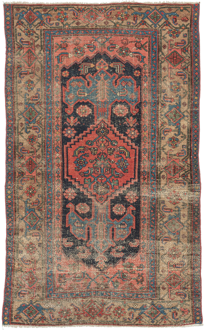 This Kurdish rug was handwoven during the early 20th century in Northwest Iran.  It features a soft red central medallion floating atop an open midnight blue field. A variation of the herati design can be found in both the medallion and the coral cornices. The meandering palmette border sits on a camel ground and is framed by two thin blue minor borders.