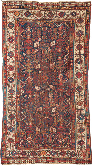 This Shekarlu rug was woven at the turn of the 20th century. The Shekarlu are a Lori-speaking tribe of the Qashqa'i Confederacy.

It features a spectacular all-over field chock full of totemic polygons, rosettes, serrated combs, and various types of animals and protection symbols. Nicely balanced yet yet still with a free flowing rhythm. It features reds, lively blues, sunny yellows, sage, brown and bright ivory on a indigo ground. The whole is framed by a stark white border