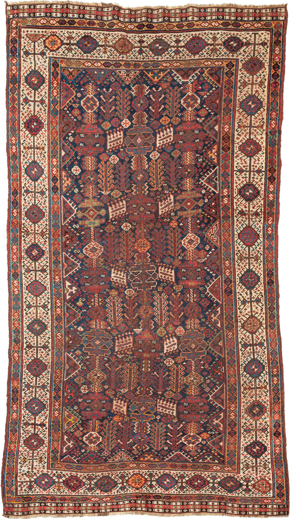 This Shekarlu rug was woven at the turn of the 20th century. The Shekarlu are a Lori-speaking tribe of the Qashqa'i Confederacy.

It features a spectacular all-over field chock full of totemic polygons, rosettes, serrated combs, and various types of animals and protection symbols. Nicely balanced yet yet still with a free flowing rhythm. It features reds, lively blues, sunny yellows, sage, brown and bright ivory on a indigo ground. The whole is framed by a stark white border