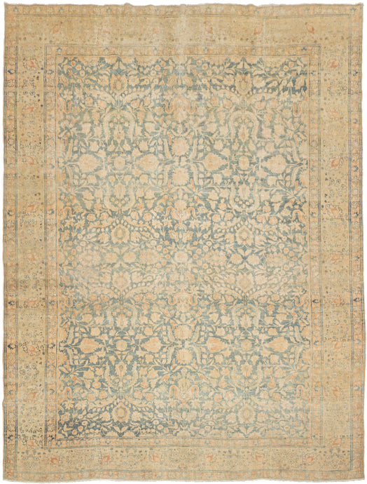 Tabriz It features an ornate all-over design of muted floral sprays in various soft shades of caramel, khaki and terracotta on an undulating indigo ground. It is framed by a border of alternating palmettes on meandering vines on a calm yellow ground. Very decorative, a soft, and elegant piece that will subtly elevate any space.