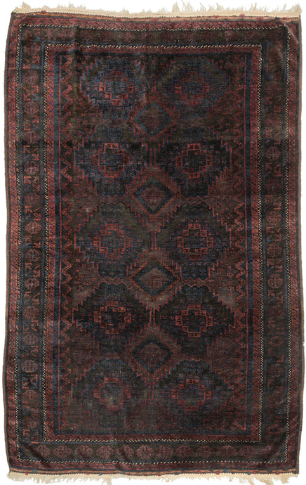  Timuri Baluch was handwoven during the second quarter of the 20th century in Western Afghanistan.

It features a lattice pattern of stepped diamonds and serrated polygons. With lush deep blue and red wool with a dark but lustrous complexion. The addition of a dark brown which has oxidized naturally sculpts the pattern and gives the shapes the feeling of floating in space. Bright speckles of white cotton have been woven around the main border adding a subtle touch of electricity. weft float