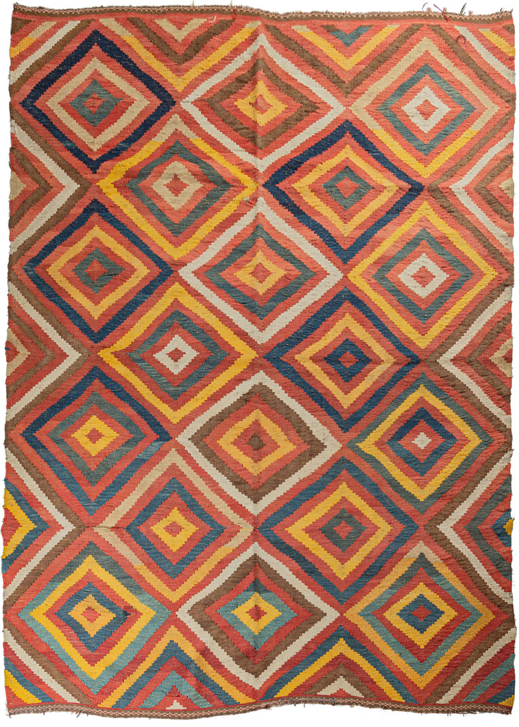 Lori Kilim featuring concentric diamond shapes in yellows, blues, browns, and whites on a red field. The simplicity of the design is enriched by the lovely abrash throughout, the subtle color changes adding to the visual interest of the rug.