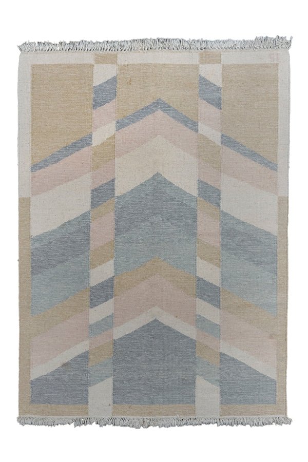 This Rolakan kilim was handwoven in Sweden during the middle of the 20th century.

It features a geometric design of stacked triangles that is broken up by two striped columns. This seemingly simple design can be read multiple ways. The soft palette of light and dark blues, ivory and copper softens the composition. The initials 