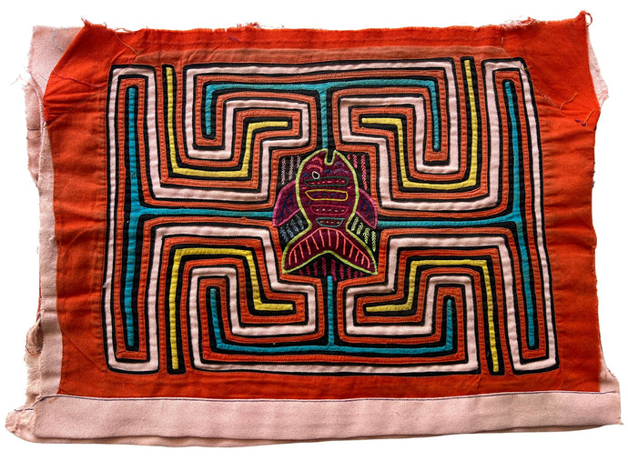 Vintage Mola cloth handmade by the Guna (previously spelled Kuna) people of the San Blas Islands.  Mola is a reverse appliqué technique, similar to the technique used in quilting but using multiple layers of different-colored cloth that are first sewn together before a design is created by cutting away different layers. These cloths are traditionally made in pairs to be worn on the front and back of women's blouses.  This Mola features a vertical fish