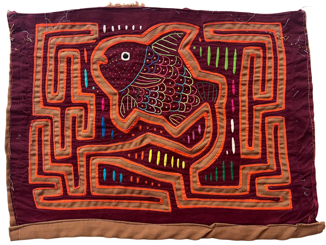 Vintage Mola cloth handmade by the Guna (previously spelled Kuna) people of the San Blas Islands.  Mola is a reverse appliqué technique, similar to the technique used in quilting but using multiple layers of different-colored cloth that are first sewn together before a design is created by cutting away different layers. These cloths are traditionally made in pairs to be worn on the front and back of women's blouses.  This Mola features a colorful fish that almost appears to be jumping in the air.