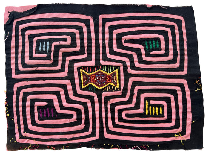 Vintage Mola cloth handmade by the Guna (previously spelled Kuna) people of the San Blas Islands.  Mola is a reverse appliqué technique, similar to the technique used in quilting but using multiple layers of different-colored cloth that are first sewn together before a design is created by cutting away different layers. These cloths are traditionally made in pairs to be worn on the front and back of women's blouses.  This Mola features a maze like pattern with a face in the center. 