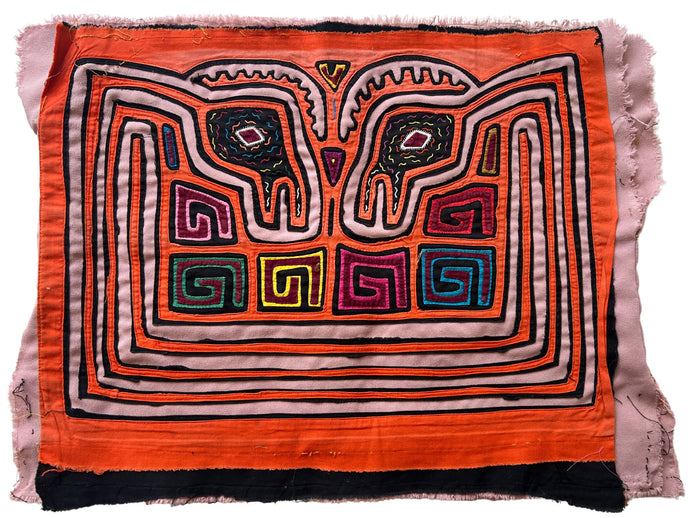 Vintage Mola cloth handmade by the Guna (previously spelled Kuna) people of the San Blas Islands.  Mola is a reverse appliqué technique, similar to the technique used in quilting but using multiple layers of different-colored cloth that are first sewn together before a design is created by cutting away different layers. These cloths are traditionally made in pairs to be worn on the front and back of women's blouses.  This Mola features a psychedelic pattern of confronting bird heads. 