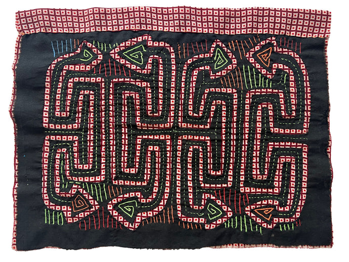 Vintage Mola cloth handmade by the Guna (previously spelled Kuna) people of the San Blas Islands.  Mola is a reverse appliqué technique, similar to the technique used in quilting but using multiple layers of different-colored cloth that are first sewn together before a design is created by cutting away different layers. These cloths are traditionally made in pairs to be worn on the front and back of women's blouses.  This Mola features a pattern of abstracted snakes. 