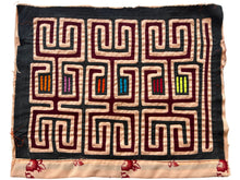 Vintage Mola cloth handmade by the Guna (previously spelled Kuna) people of the San Blas Islands.  Mola is a reverse appliqué technique, similar to the technique used in quilting but&nbsp;using multiple layers of different-colored cloth that are first sewn together before a design is created by cutting away different layers. These cloths are traditionally made in pairs to be worn on the front and back of women's blouses.  This Mola features a graphic geometric pattern on a black ground. 