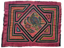 Vintage Mola cloth handmade by the Guna (previously spelled Kuna) people of the San Blas Islands.  Mola is a reverse appliqué technique, similar to the technique used in quilting but using multiple layers of different-colored cloth that are first sewn together before a design is created by cutting away different layers. These cloths are traditionally made in pairs to be worn on the front and back of women's blouses.  This Mola features parrot sitting on a branch. 