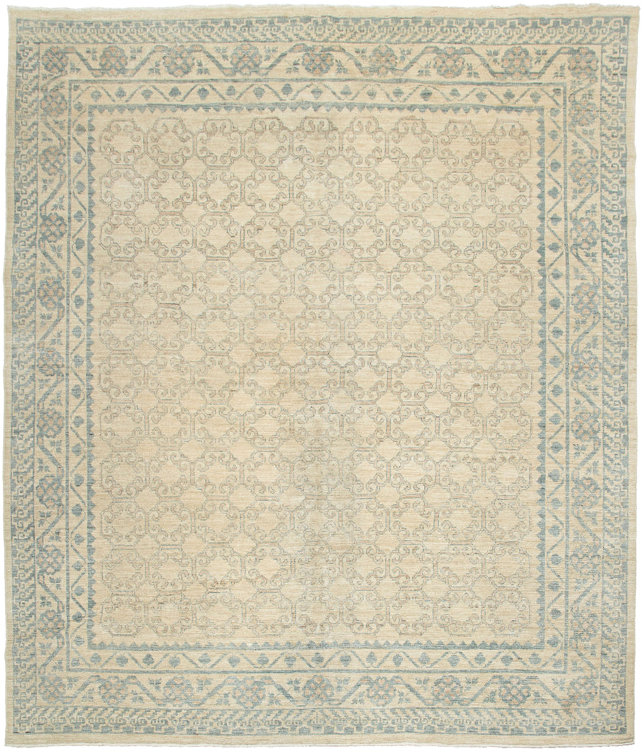 This rug features an all-over design of interconnected soft mauve latticework outlined in powder blue on a cream ground. The main border is a wonderful alternating pomegranate motif and the perimeter border features abstracted cloudbands. A perfect showcase of classic Khotan patterning which is a wonderful hybrid of both Central and Eastern Asian design. 