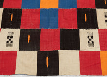 This blanket was likely woven by the Fulani people in Mali during the middle of the 20th century.

It was woven in multiple stripes which have been attached horizontally. It features an eye dazzling checkerboard composed of white, black, red, green, blue and a sunny yellow-orange. Four individual squares around the perimeter are woven with the red-yellow-green tricolor of the Malian flag.

Via The Metropolitan Museum of Art The checkerboard, a basic West African composition, ultimately may derive from