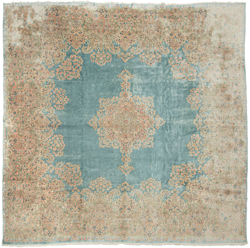 This Kerman rug handwoven during the second quarter of the 20th century.


It features a central medallion floating above an open turquoise ground and framed by a large and elegant border. The medallion and border are both composed of beautifully detailed floral sprays in pastel pinks, reds, seafoam green, copper, and gold and khaki. 