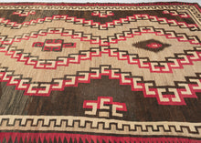 This Antique Navajo rug was handwoven in the Southwest USA during the first quarter of the 20th century.

This striking rug features jagged concentric lines vibrating from a small central diamond. The sharp angles and mottled tones of gray, brown, and red give the lines a dimensionality and they appear to float on the mottled gray inner field and variegated brown outer field. Framed by an inner dentil border and a red and brown serrated perimeter that has a flame like quality.
rare large size