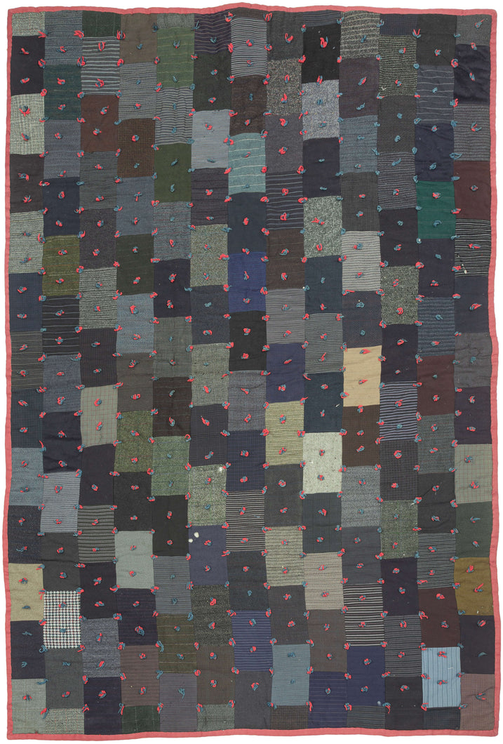 Burkino Faso mudcloth striking mid-20th century quilt embodies the resourcefulness and artistry of traditional quilt-making. Hand-stitched from an array of deep-toned fabrics, its patchwork design features a rich interplay of stripes, plaids, and solid colors, giving the piece an understated yet complex visual depth. by its vibrant yarn ties—knotted in red and blue—adding texture, warmth, and a tactile element that enhances its handmade charm. These ties, a signature of Southern quilting tra