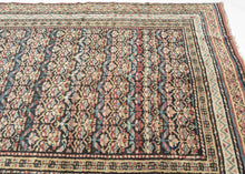 Quchan KURD It features a fine and densely woven lattice of repeating floral motifs in various blues, red, yellow, green, peach, brown and ivory set against an indigo ground. The interconnected patterning and consistent use of color and spacing create a mesmerizing rhythm. Nicely framed by a series of larger borders of shapes and rosettes and thinner simple candy cane stripes in an array of tones