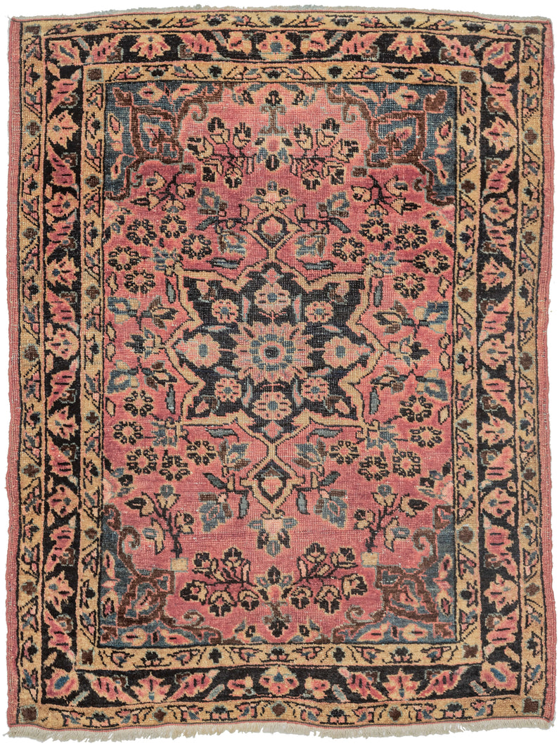 This Sarouk rug was handwoven during the second quarter of the 20th century.

It features of an deep navy central medallion on a crimson ground. The field is filled with fine floral sprays and balanced by four scalloped cornices woven in light blue. The border is composed of a straightforward floral meander in the same deep navy almost black ground of the central medallion