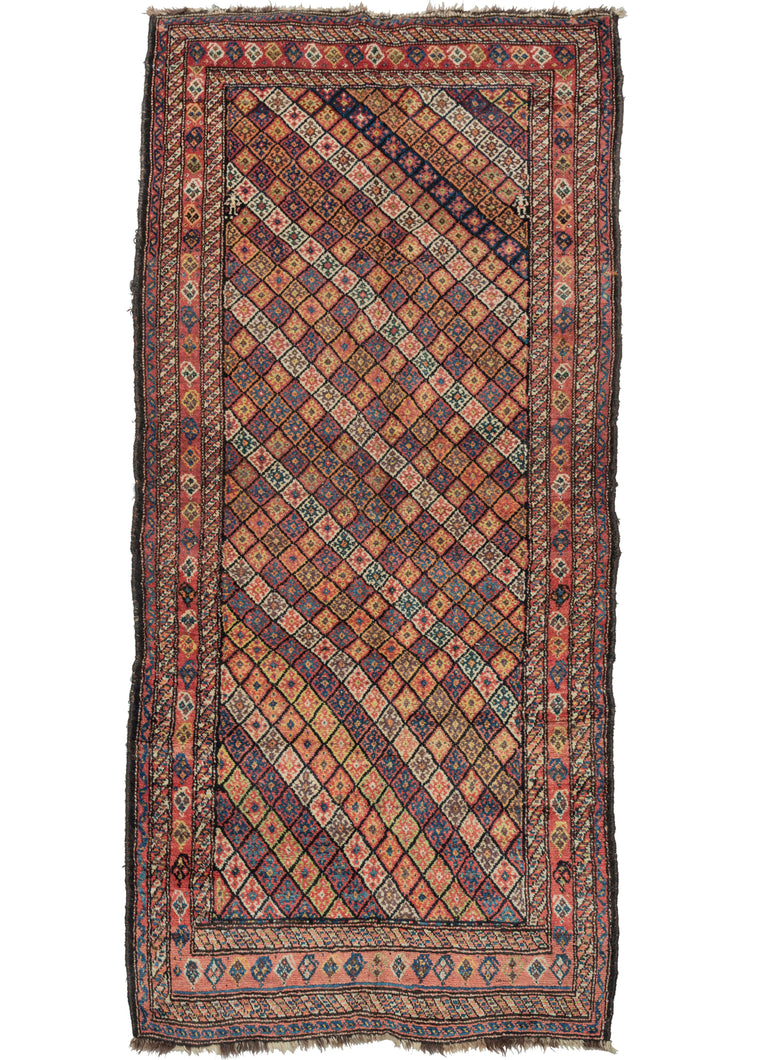 19th century south Persian lori rug featuring a classic repeating diamond pattern set in a diagonal. Note the classic candy-cane borders found in many rugs woven in the Zagros. The main border continues the diamond motif of the main design but in a straight line. Two little figures at the top on the left and right of the rug add a touch of whimsy.