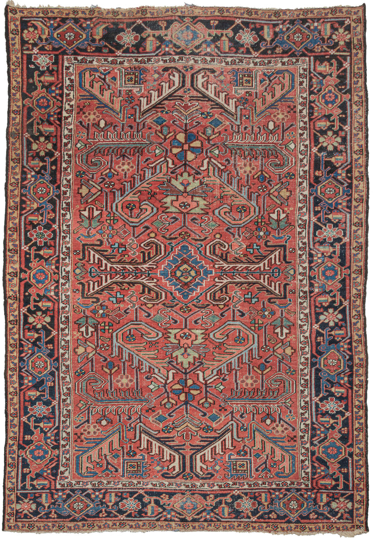 Antique Persian Heriz roomsize rug featuring an allover design of scrolling two-tone leaves in a variety of color combinations such as black and white, turquoise and coral, and green and red on a patinated red ground. All-over designs are less common on Heriz rugs which most often feature large central medallions. The main border is composed of alternating rosettes and serrated leaves in a similar yet distinct fashion to those in the field.