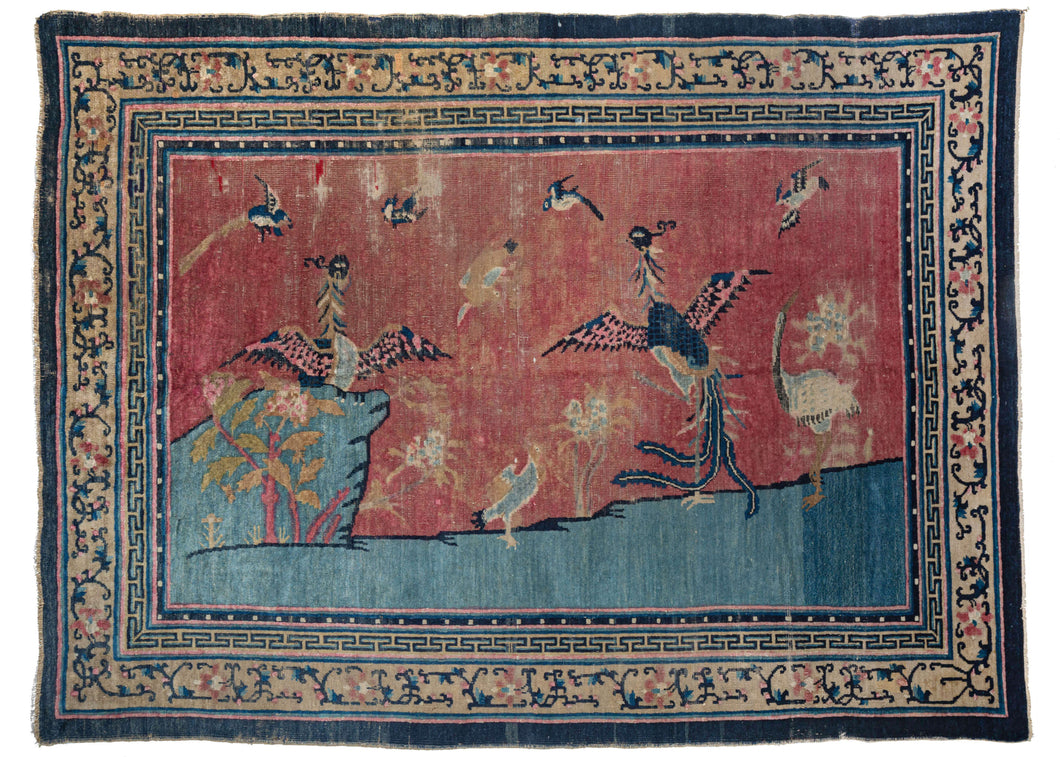 Antique Pictorial Peking area rug featuring  a pictorial scene on an icey blue foreground and a hot pink background. A variety of auspicious birds are showcased, most prominently two Fenghuang about to take flight and a crane standing on one leg. The rug has been 