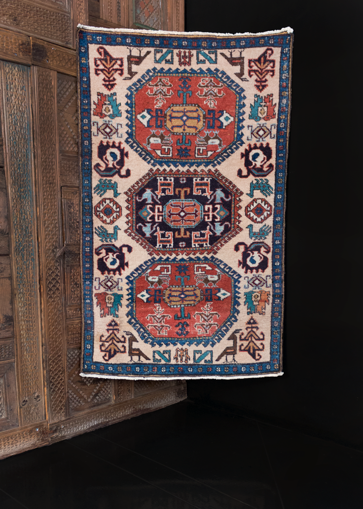 Ardabil rug handwoven in third quarter of 20th century in Northwest Iran. Soft ivory field with animal figures and geometric design in red, green and blue. Black central medallion.