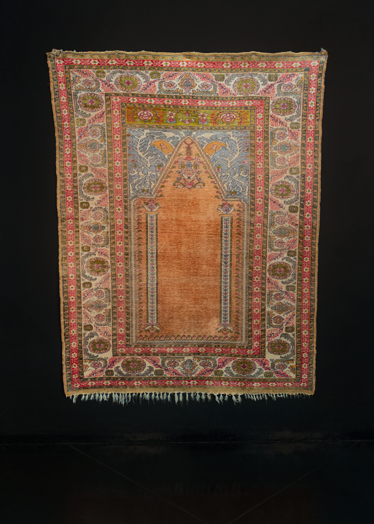 Silk Kayseri handwoven during middle of 20th century in Central Turkey. The Mihrab, or prayer niche, features a velvety orange field with two ivory columns and a hanging lantern. Pink, aqua, chartreuse and siren red. 