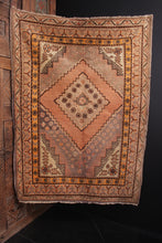 Khotan rug handwoven second quarter of 20th century in Northwest China. Orange-pink peach tones and soft grey browns. Slightly off center medallion framed by small flowers 