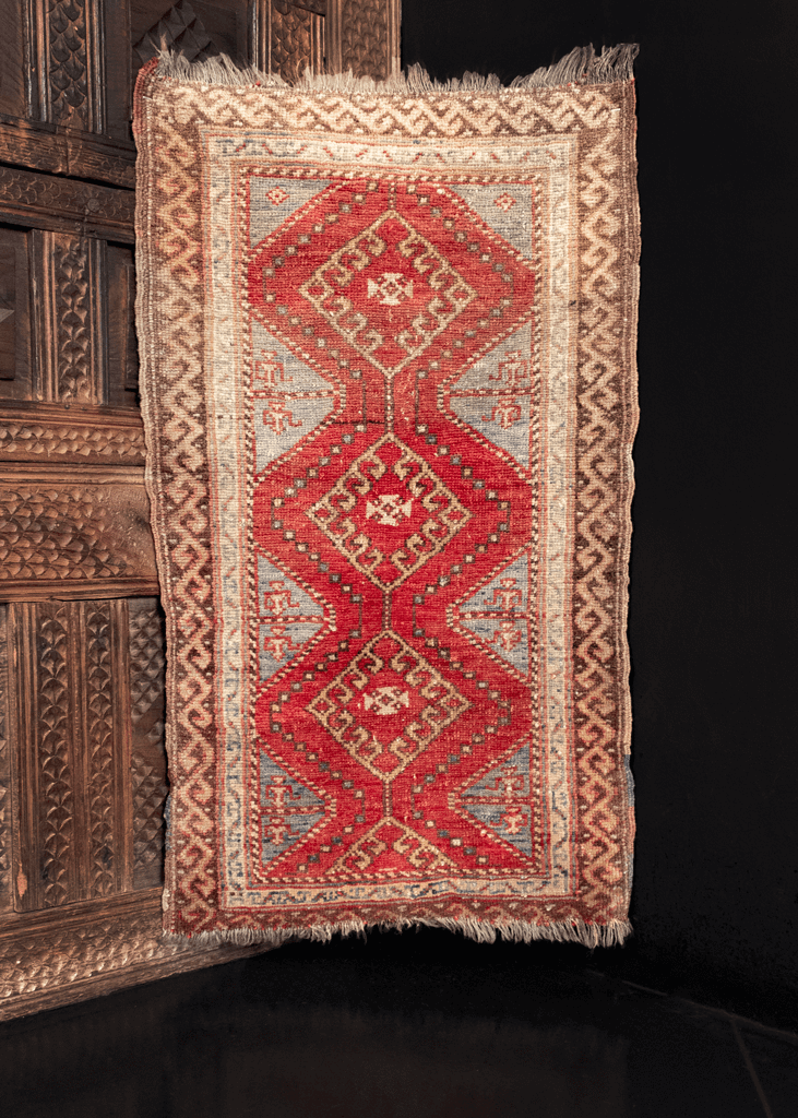 Yastik handwoven during second quarter of 20th century in Turkey. Three hooked diamonds form central design in bold red and a soft blue. 