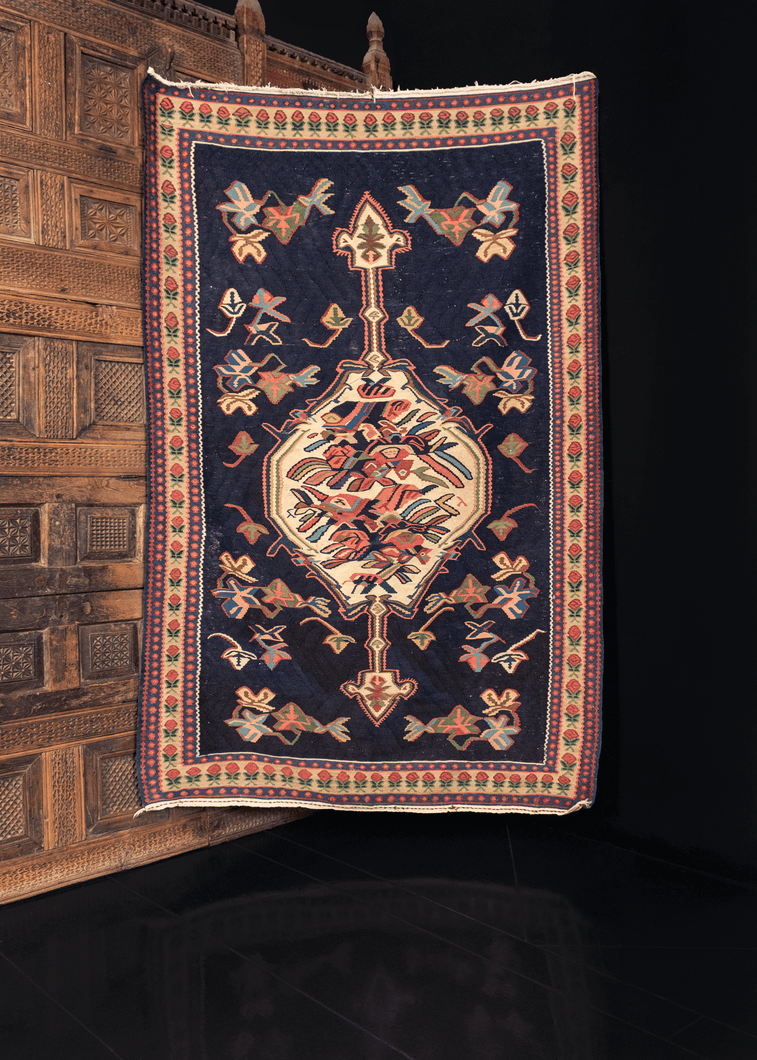 Bidjar kilim handwoven during middle of 20th century. Ivory abstracted rosette central medallion atop a navy field. 