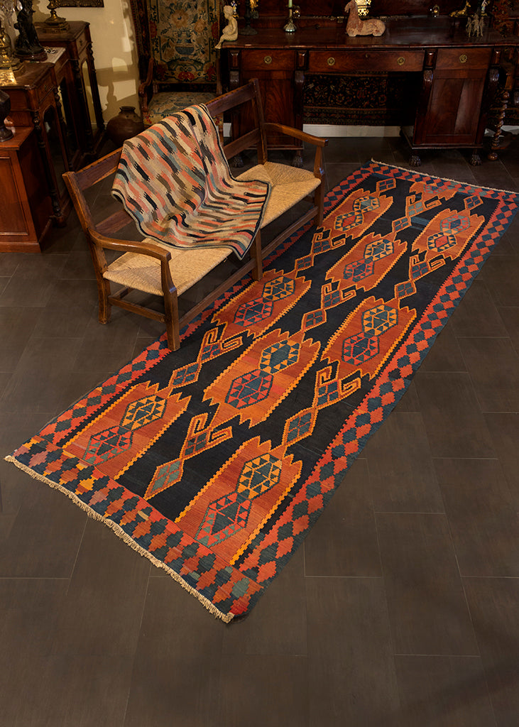 Caucasian Kuba runner handwoven during second quarter of 20th century. Geometric design, woven in a palette of indigo blue, burn orange, and soft red. 