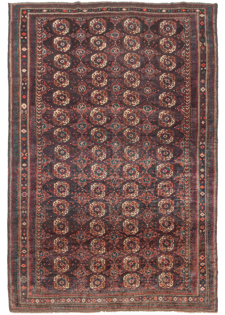 Large Afghan Turkmen purple toned rug featuring a traditional Tekke gül design with both burnt and bright orange, ivory, and green accents on a soft multi-shade aubergine ground. A precursor to the 