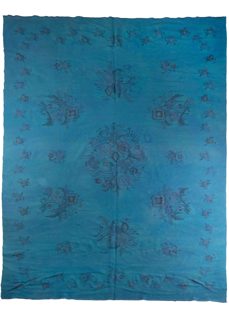 Mid century Romanian kilim overdye featuring a bright blue field. Remnants of the original design of floral bouquets are still visible through the deep dye. 