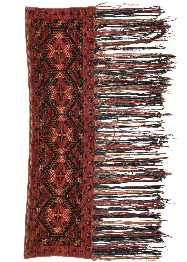 Ersari Turkmen Trapping that features a simple and straightforward color palette of earthy reds, ivory, yellow and navy. The design is composed of six ikat inspired güls which are framed by small borders and simple protection symbols. The highlight of the piece is the wonderful hanging which alternates between earthy red, rusty orange and deep indigo.