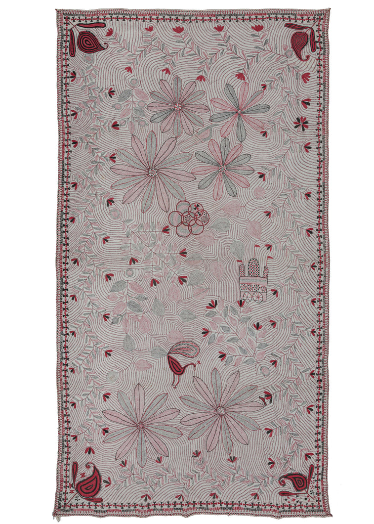 Antique large Bengali Kantha featuring a repeat field of flowering vines and curving lines as a backdrop to a small off-center mandala and large-scale floral forms. The addition of a peacock and a Vimana or flying palace adds some serious interest. The large-scale floral forms almost feel like fireworks exploding in the sky. The whole composition is flanked by richly rendered paisley or 